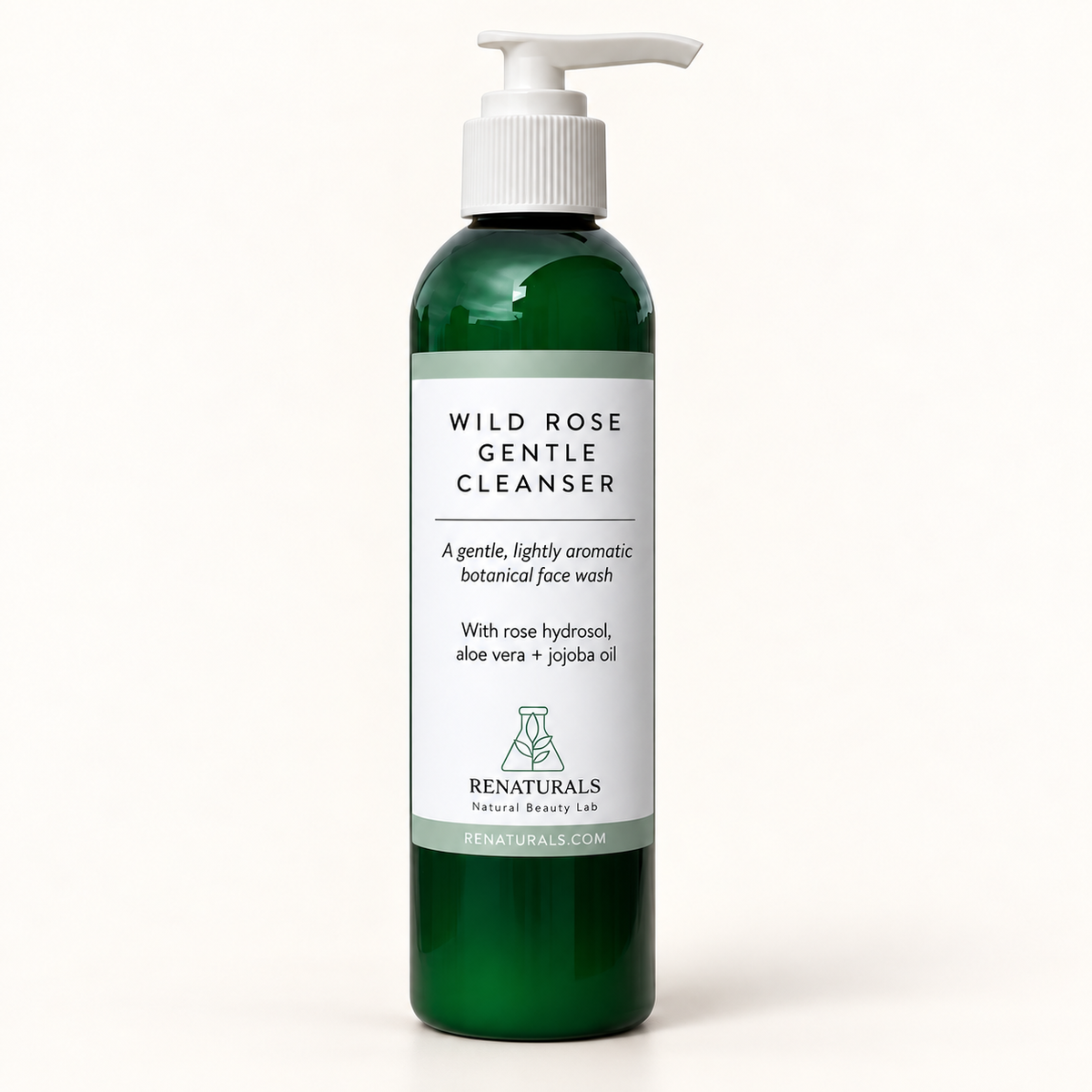 RENATURALS Wild Rose Gentle Cleanser in a green bottle with a white pump and sage-and-white label on a smooth ivory background.